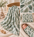 A collage showing a soft baby blanket or swaddle with a green leaf print. The main panel shows the blanket draped over a woven basket on a knitted cream surface, with a stuffed bunny nearby.