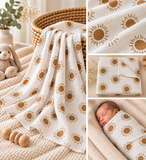 A collage showing a white muslin blanket with a brown sun print, draped over a woven basket and knitted blanket, with close-up fabric detail and a baby wrapped in the blanket.